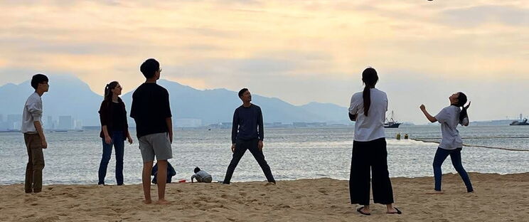 Gruppe junger Menschen spielen Volleyball am Strand in Hongkong