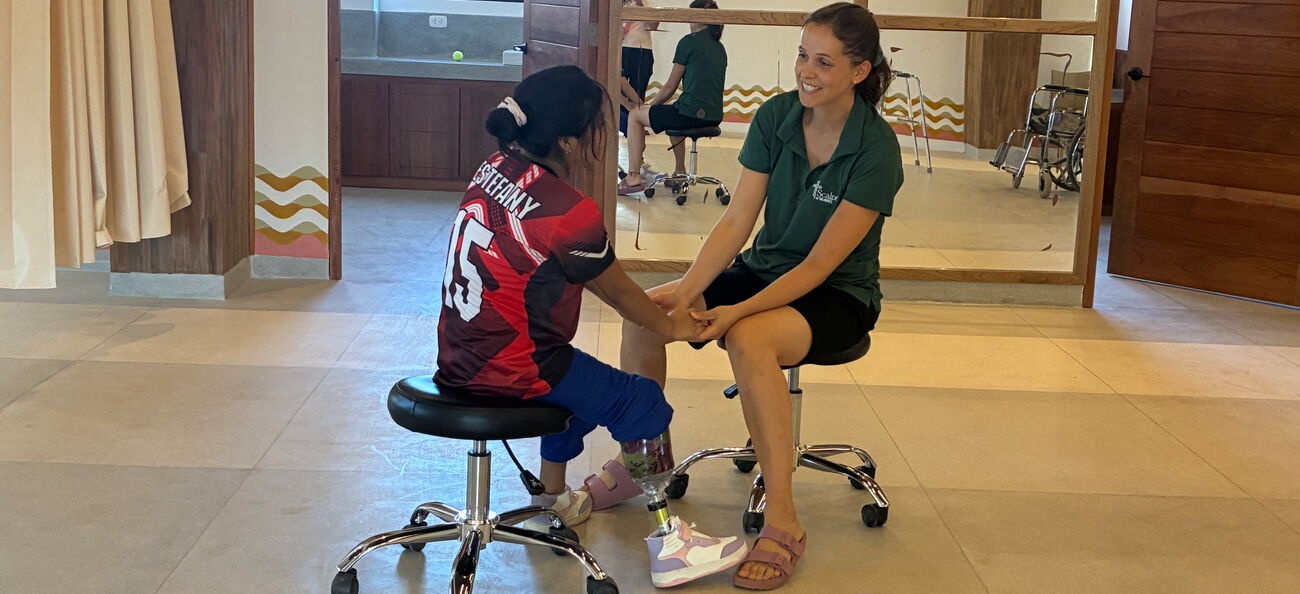 Kruse mint einem Mädchen mit Beinprotese auf zwei Rollhockern