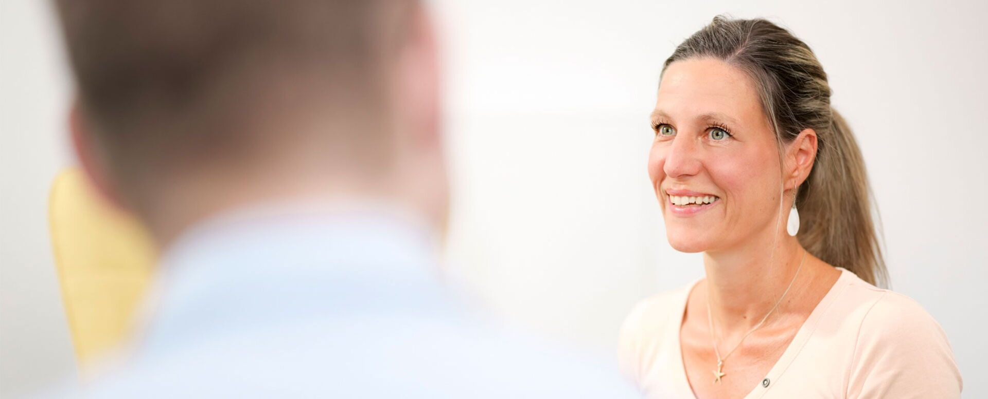 Lächelnde Frau im Gespräch in hellen Büro