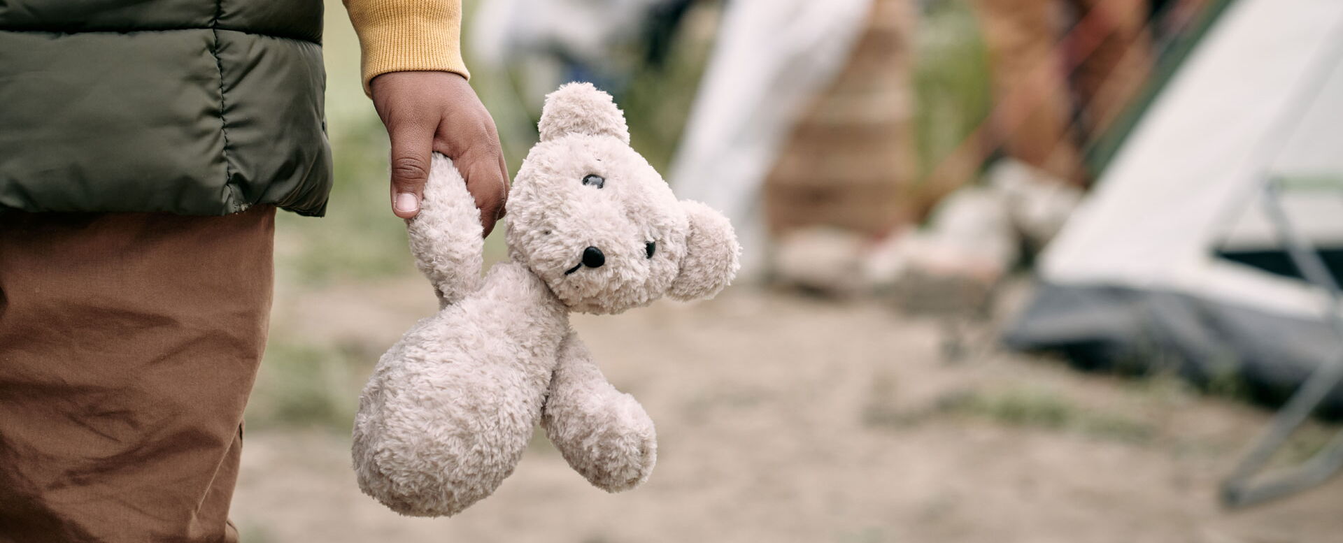 Hand eines Kindes, das ein Teddybär hält