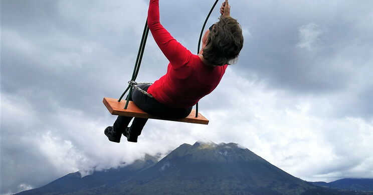 Esther Neufeld auf einer Schaukel mit Bergen und See im Hintergrund