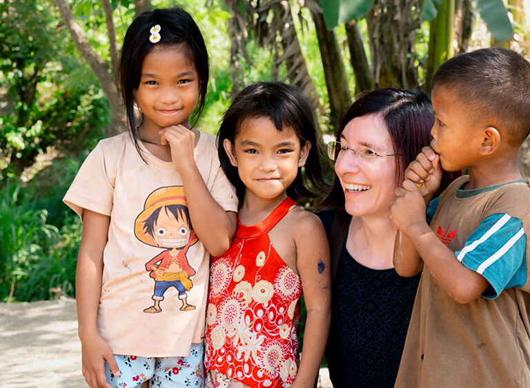 Lächelnde Frau mit glücklichen Kindern im Dschungel