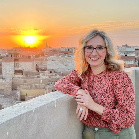 Portraitbild Pauli über den Dächern einer Stadt mit Sonnenuntergang