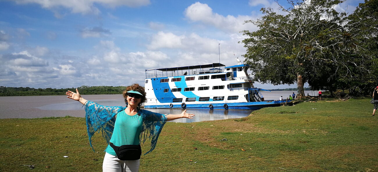 Esther Neufeld mit ausgebreiteten Armen vor einem Schiff an einem See